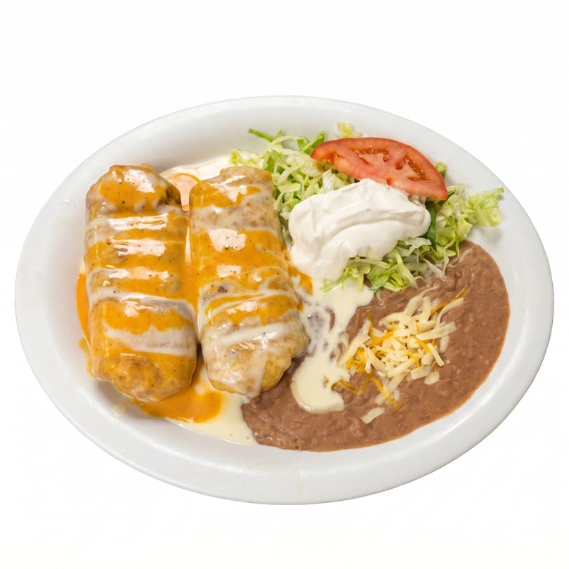 Two burritos covered in orange and white sauce, with refried beans, shredded lettuce, and sour cream.